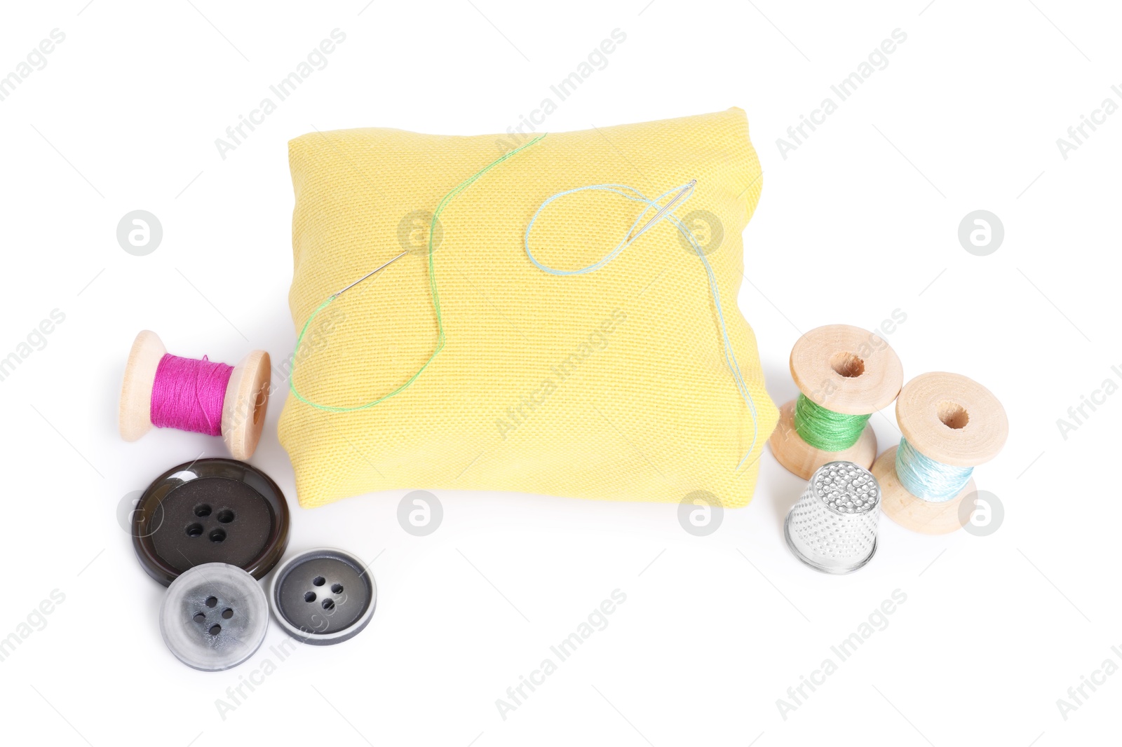 Photo of Pincushion, sewing needles, spools of threads, buttons and thimble isolated on white