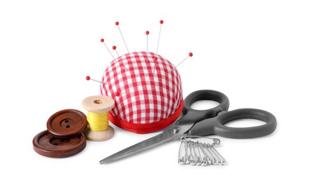 Photo of Pincushion with sewing pins, scissors, spool of thread and buttons isolated on white