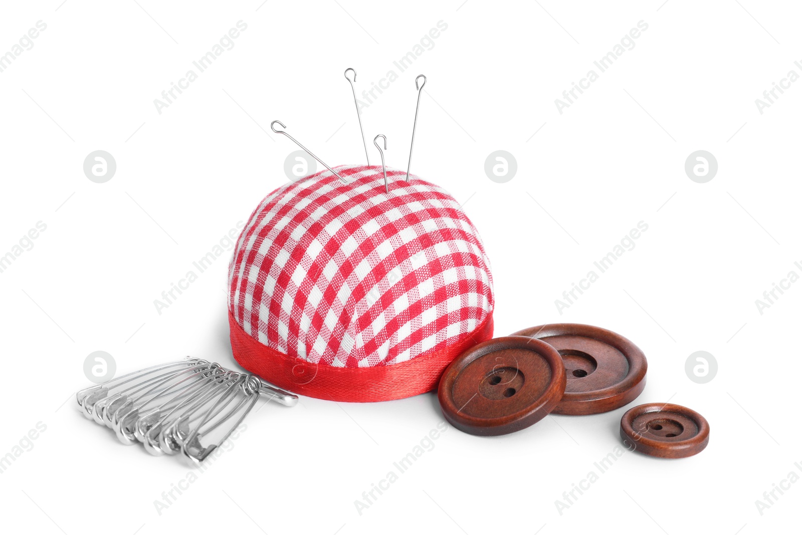 Photo of Pincushion, sewing needles, safety pins and buttons isolated on white