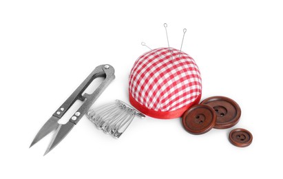 Photo of Pincushion, sewing needles, safety pins, cutter and buttons isolated on white