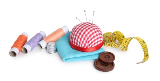 Pincushion, needles and other sewing tools isolated on white