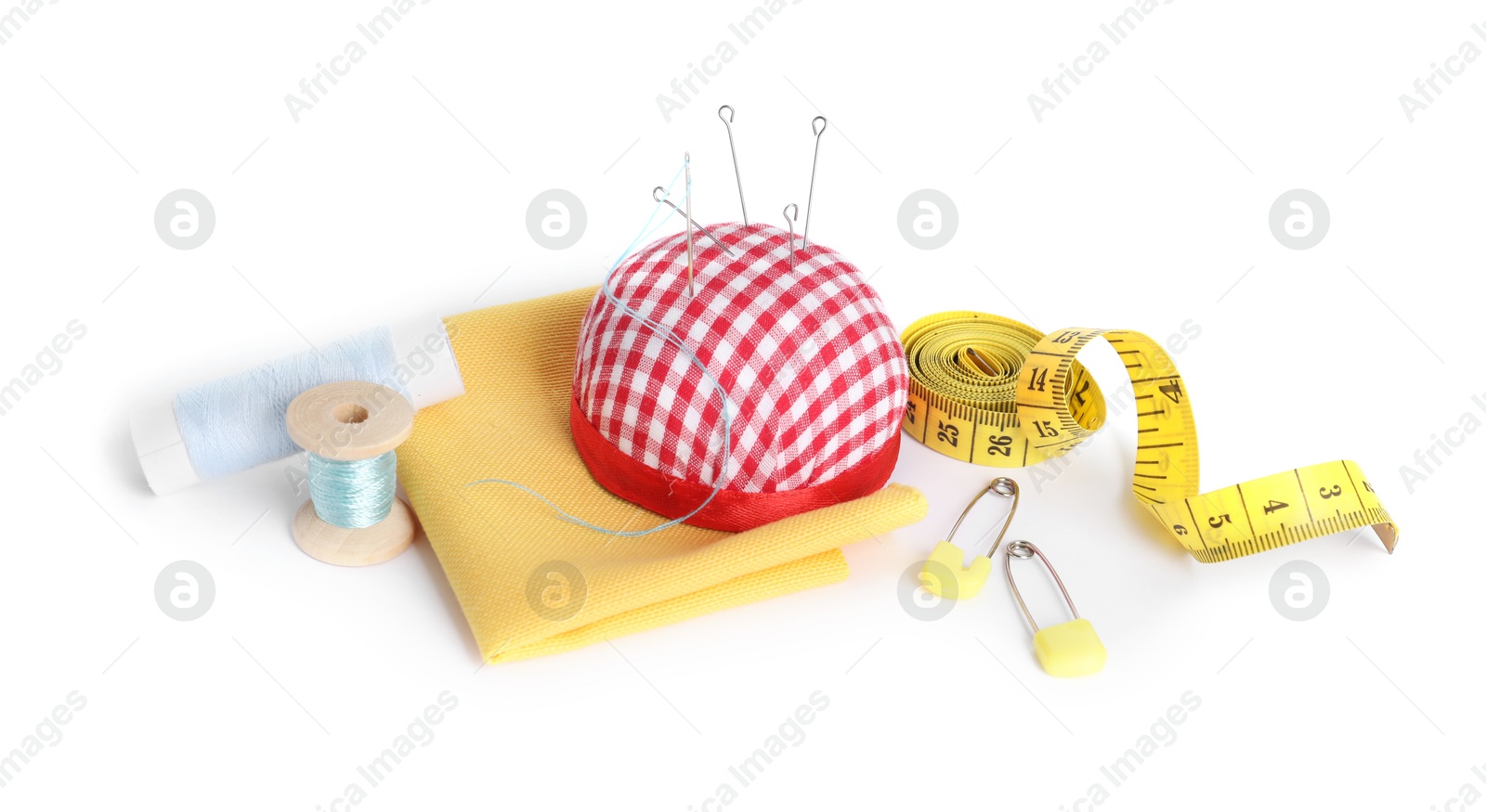 Photo of Pincushion, needles and other sewing tools isolated on white