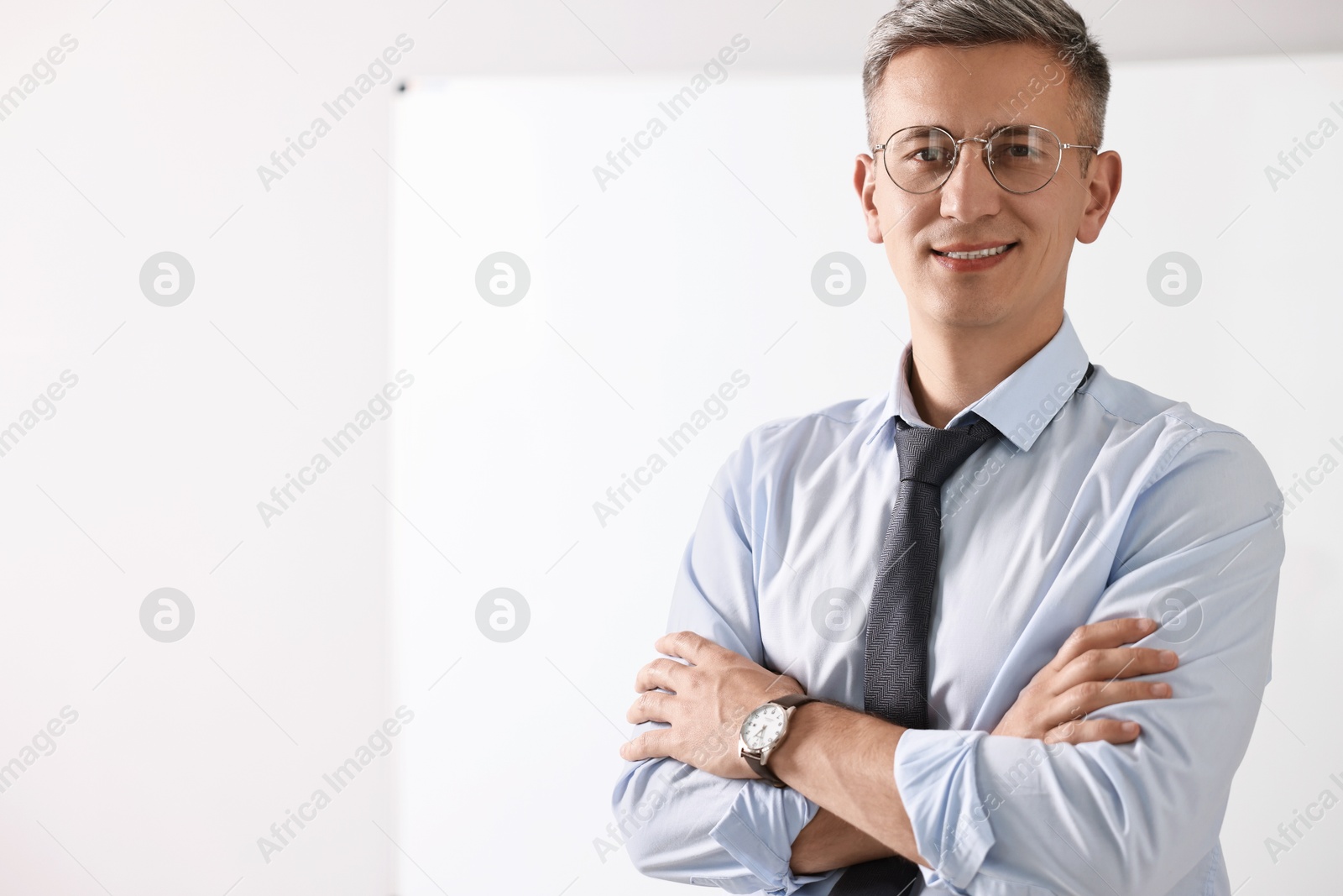 Photo of Teacher near whiteboard in classroom, space for text