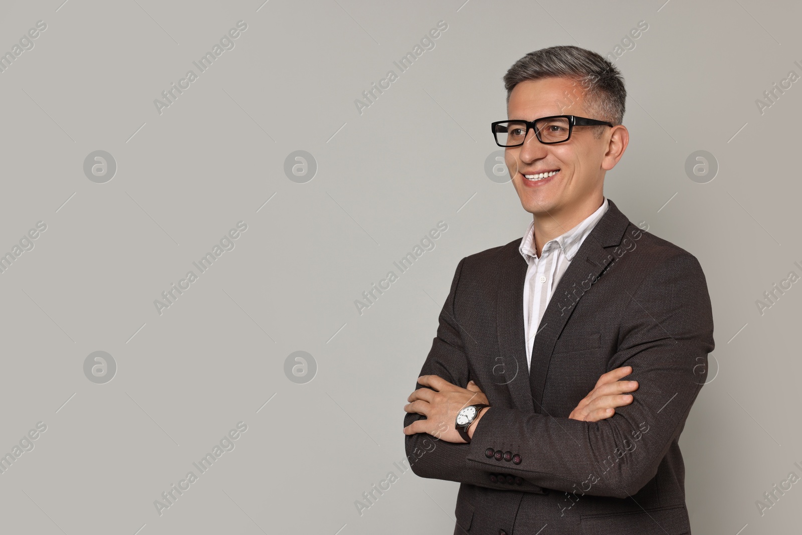 Photo of Happy man in glasses on grey background, space for text