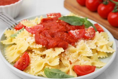 Photo of Tasty pasta with tomato sauce, cheese and basil on white table, closeup