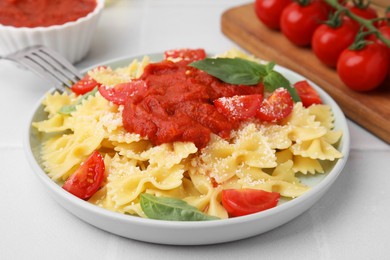 Tasty pasta with tomato sauce, cheese and basil on white table, closeup