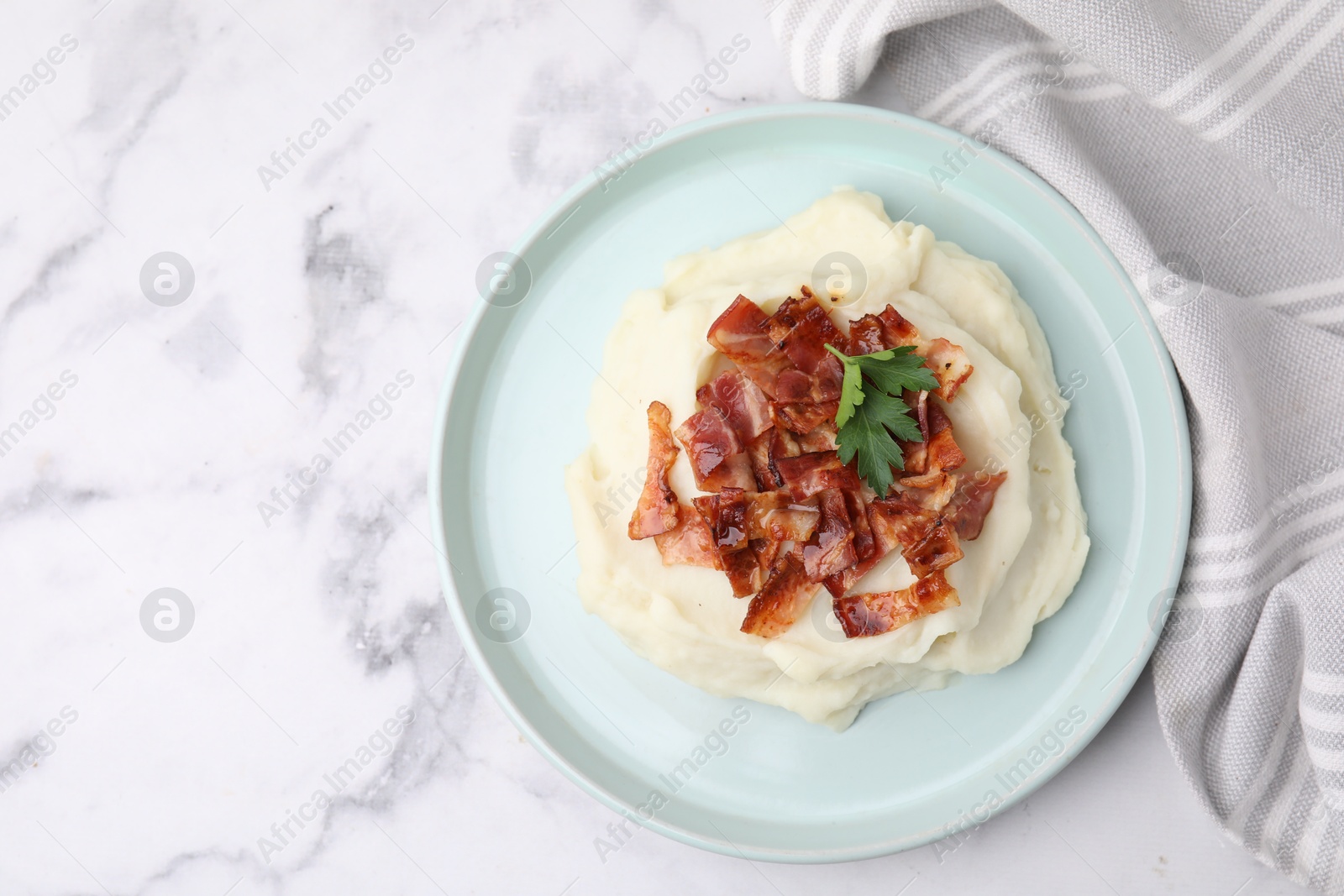 Photo of Fried bacon, mashed potato and parsley on white marble table, top view. Space for text