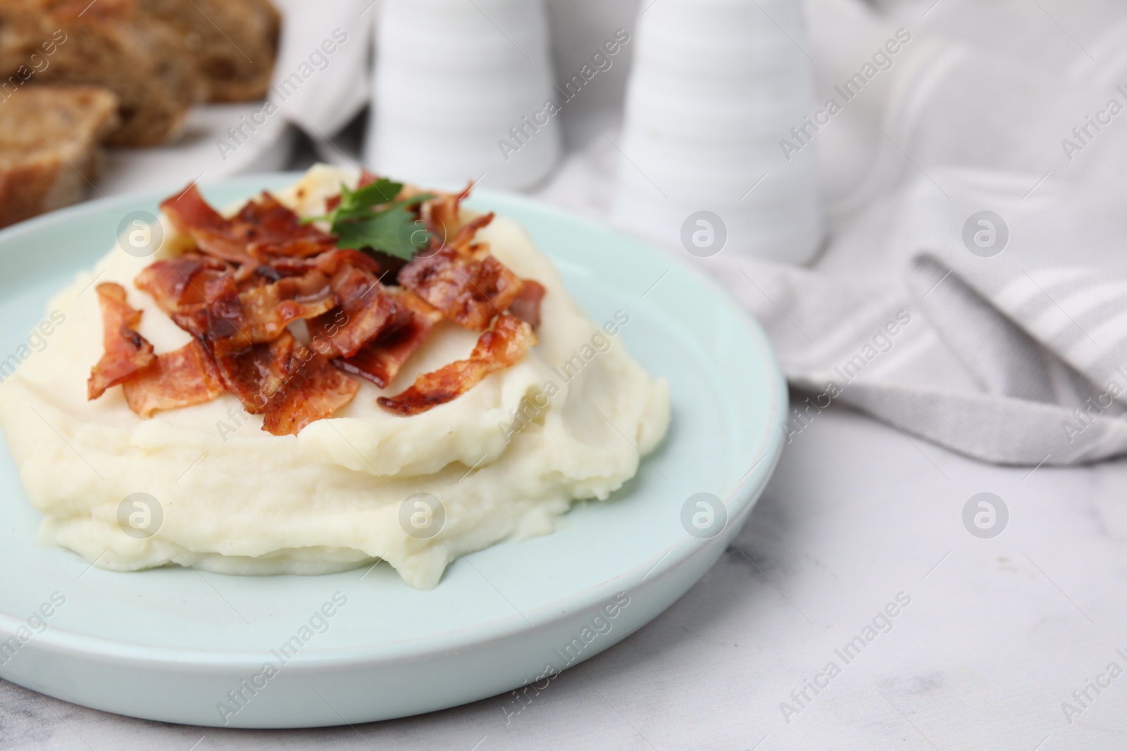 Photo of Fried bacon, mashed potato and parsley on white marble table. Space for text