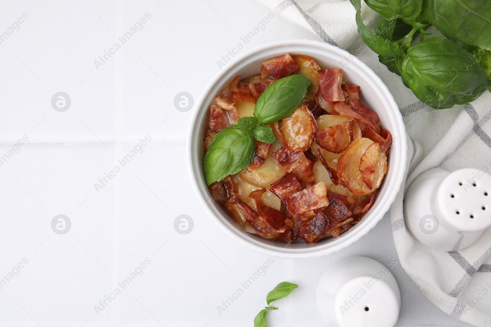 Photo of Delicious baked potatoes, bacon and basil on white table, top view. Space for text