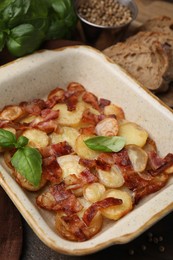 Photo of Delicious baked potatoes, bacon, basil, peppercorns and bread on table