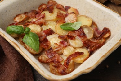 Photo of Delicious baked potatoes, bacon and basil on table, closeup