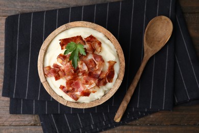 Fried bacon, mashed potato, parsley and spoon on wooden table, top view