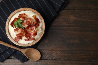 Fried bacon, mashed potato and spoon on wooden table, top view. Space for text