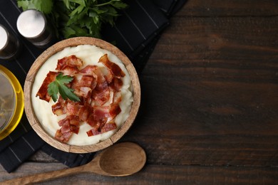 Fried bacon, mashed potato, parsley and spoon on wooden table, top view. Space for text