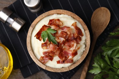 Fried bacon, mashed potato, parsley and spoon on table, top view