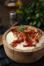 Fried bacon, mashed potato and parsley in bowl on table