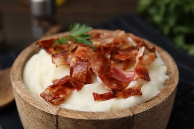 Photo of Fried bacon, mashed potato and parsley in bowl on table, closeup