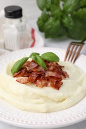 Photo of Fried bacon, mashed potato, basil and fork on table, closeup