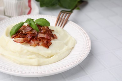 Photo of Fried bacon, mashed potato, basil and fork on white tiled table. Space for text