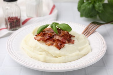 Fried bacon, mashed potato and basil on white table