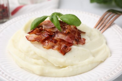 Photo of Fried bacon, mashed potato and basil on table, closeup