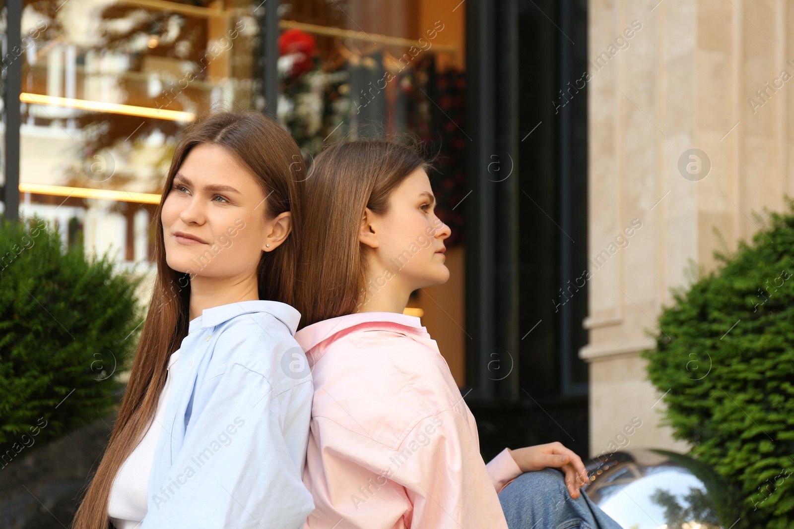 Photo of Portrait of two beautiful twin sisters outdoors