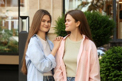 Photo of Portrait of two beautiful twin sisters outdoors