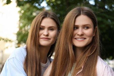 Portrait of two beautiful twin sisters outdoors