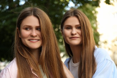 Portrait of two beautiful twin sisters outdoors