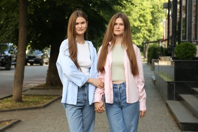 Photo of Portrait of two beautiful twin sisters outdoors