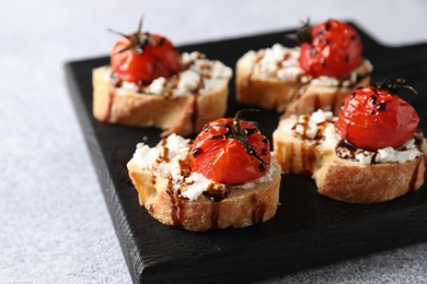 Photo of Bruschettas with ricotta cheese, tomatoes and balsamic sauce on grey table, closeup