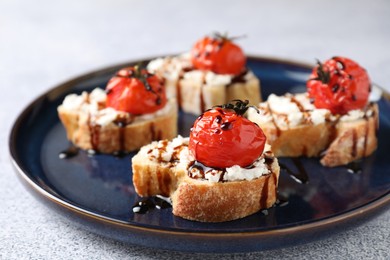 Photo of Bruschettas with ricotta cheese, tomatoes and balsamic sauce on grey table, closeup