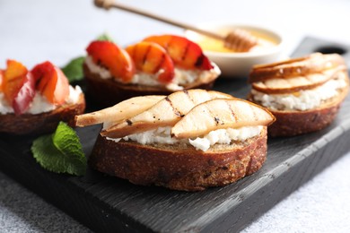 Photo of Delicious bruschettas with ricotta cheese and honey on light grey table, closeup