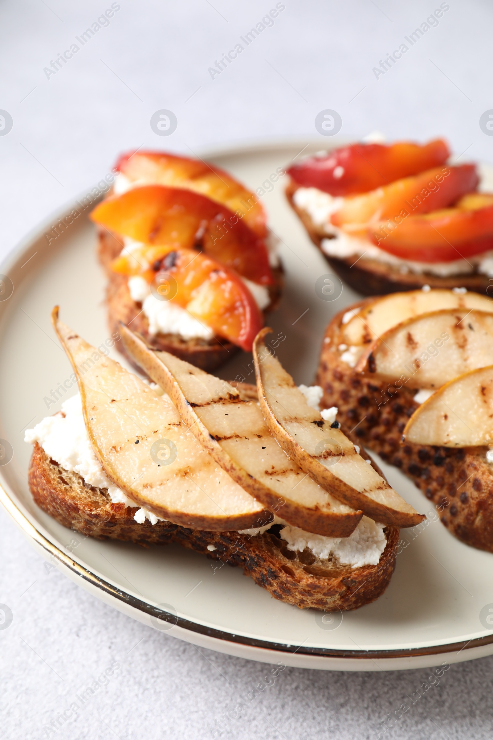 Photo of Delicious bruschettas with ricotta cheese on light grey table, closeup