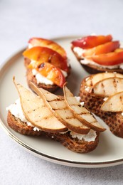 Delicious bruschettas with ricotta cheese on light grey table, closeup