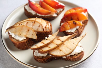 Delicious bruschettas with ricotta cheese on light grey table, closeup