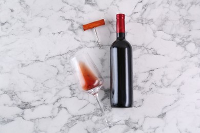 Photo of Corkscrew, bottle of wine and glass on white marble table, flat lay