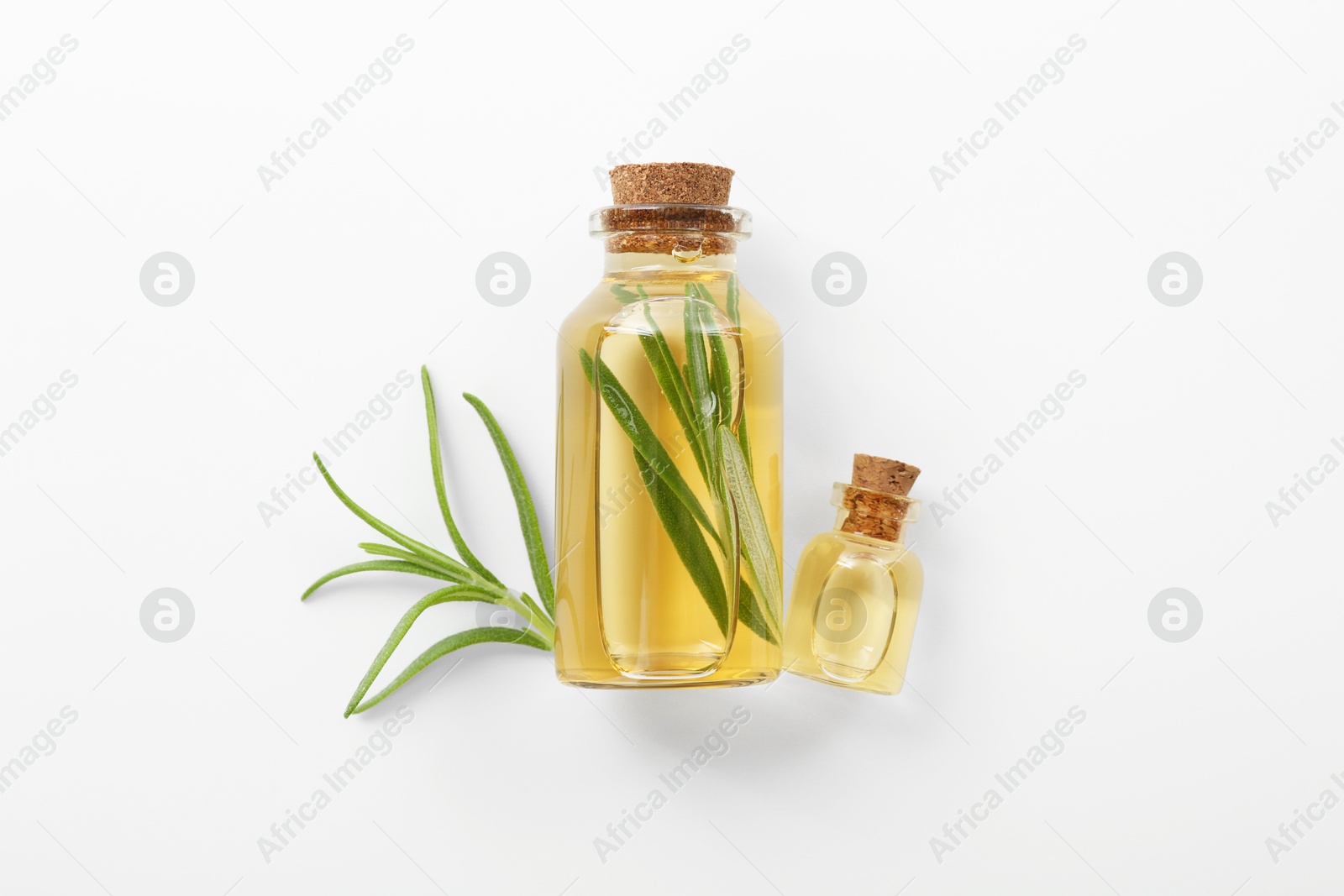 Photo of Bottles of rosemary essential oil on white background, flat lay