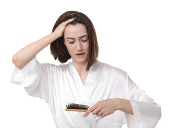 Photo of Stressed woman holding brush with lost hair on white background. Alopecia problem