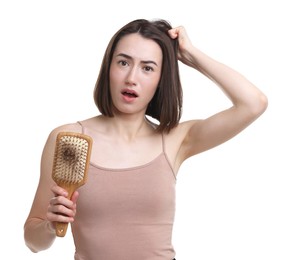 Photo of Emotional woman holding brush with lost hair on white background. Alopecia problem