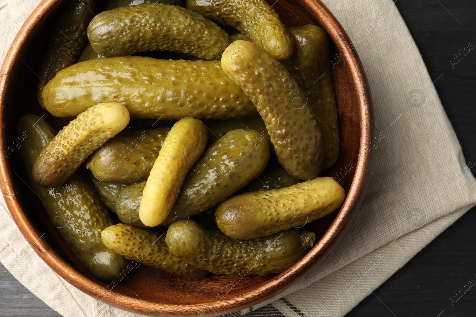 Photo of Pickled cucumbers in bowl on grey table, top view