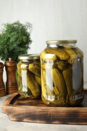 Pickled cucumbers in jars on grey table