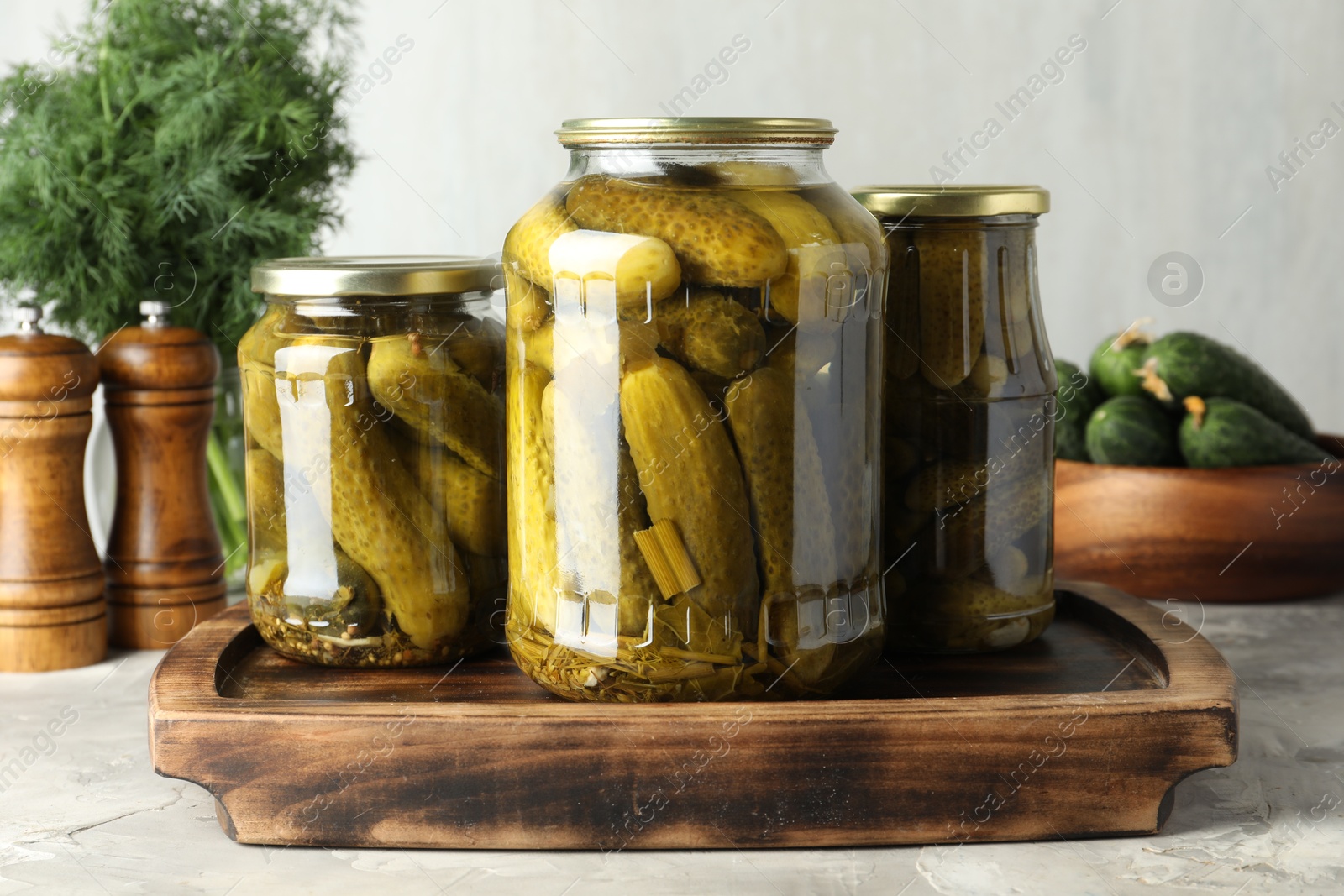 Photo of Pickled cucumbers in jars on grey table