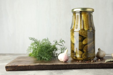 Photo of Pickled cucumbers in jar and spices on grey table. Space for text