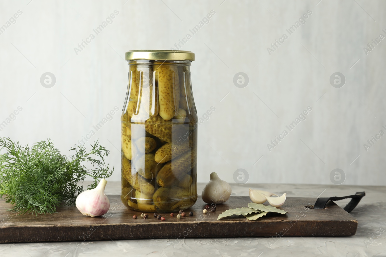 Photo of Pickled cucumbers in jar and spices on grey table. Space for text