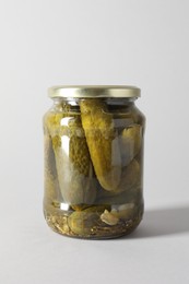 Photo of Pickled cucumbers in jar on light background