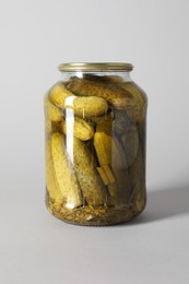 Photo of Pickled cucumbers in jar on light background