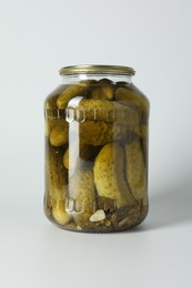 Pickled cucumbers in jar on light background