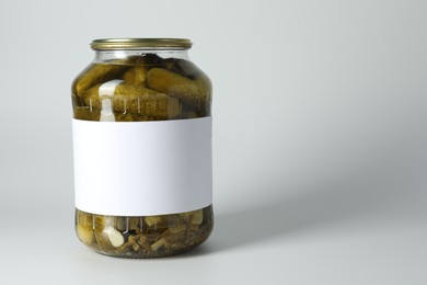 Photo of Pickled cucumbers in jar on light background. Space for text