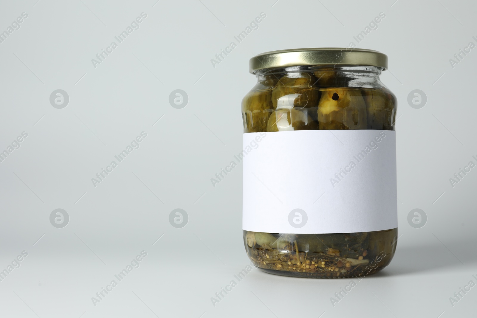 Photo of Pickled cucumbers in jar on light background. Space for text